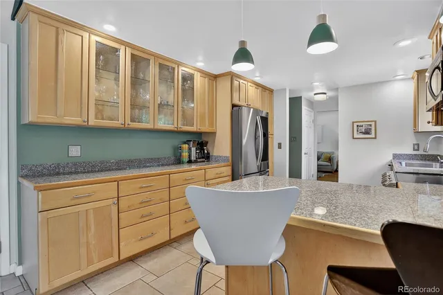 a kitchen with granite countertop a sink cabinets and refrigerator
