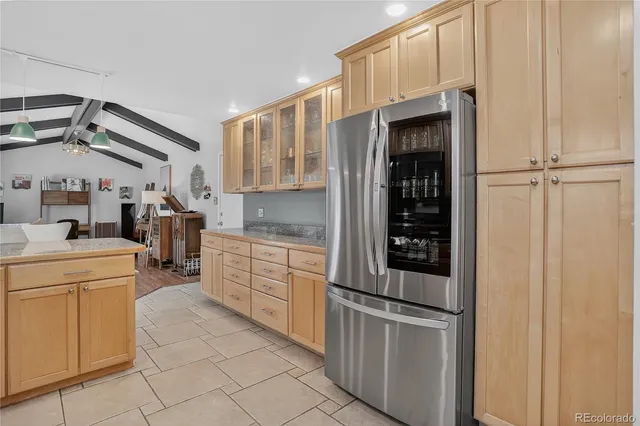 a kitchen with granite countertop a refrigerator and a sink