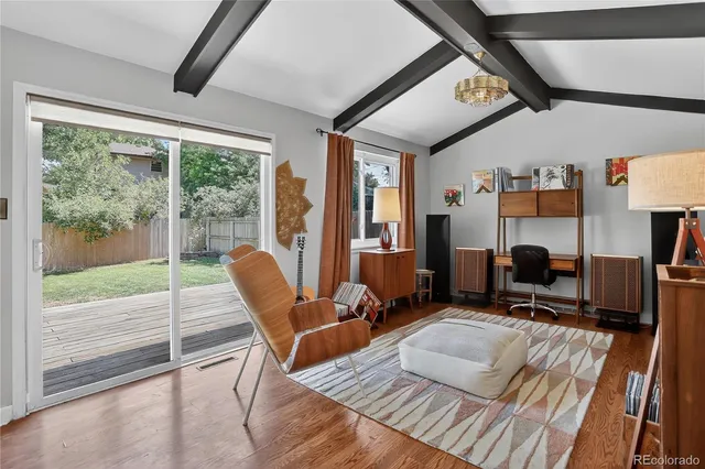a living room with furniture a flat screen tv and a floor to ceiling window