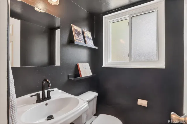 a bathroom with a sink mirror and toilet
