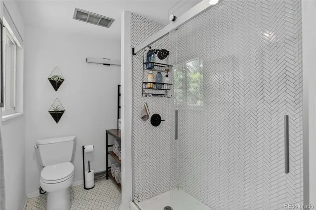 a bathroom with a toilet and a shower