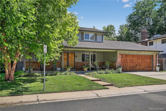 a front view of a house with a yard and trees