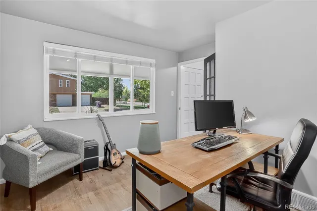 a view of a workspace with furniture and a window