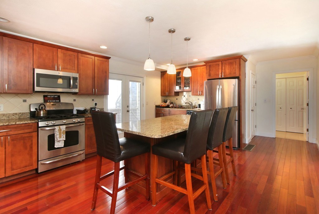 a kitchen with stainless steel appliances a dining table chairs microwave and sink