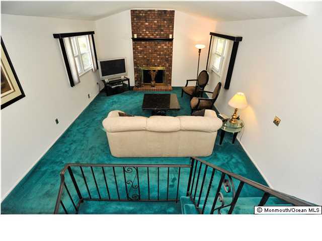 41 Eaglenest Road Freehold, NJ 07728 - Photo 12 of 16 a living room with furniture a fireplace and a floor to ceiling window