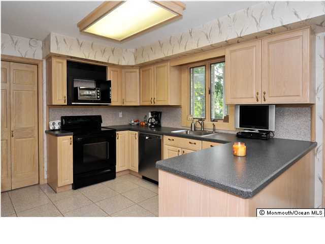 41 Eaglenest Road Freehold, NJ 07728 - Photo 5 of 16 a kitchen with stainless steel appliances granite countertop a stove a sink and a microwave