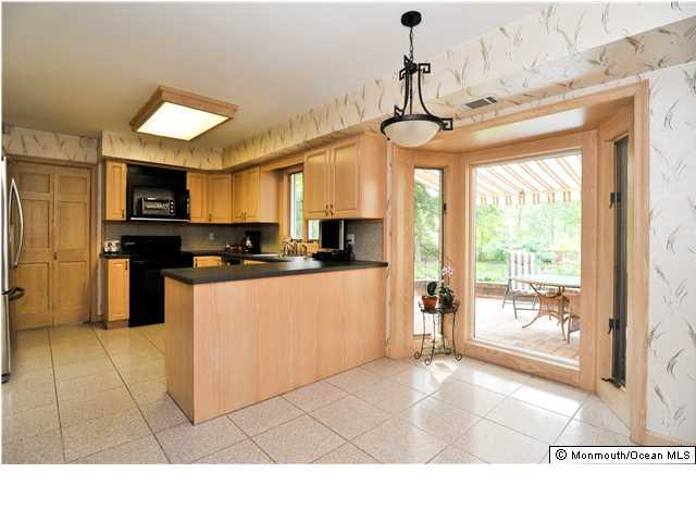 41 Eaglenest Road Freehold, NJ 07728 - Photo 7 of 16 a kitchen with stainless steel appliances granite countertop a stove top oven a refrigerator a sink dishwasher with a dining table and chairs