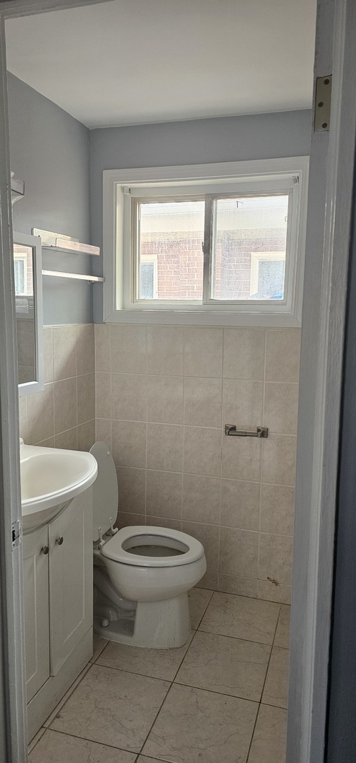 5115 North Springfield Avenue, Unit B Chicago, IL 60625 - Photo 9 of 11 a bathroom with a toilet a sink and a window