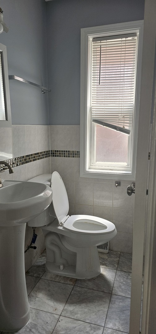 5115 North Springfield Avenue, Unit B Chicago, IL 60625 - Photo 10 of 11 a bathroom with a toilet sink and mirror