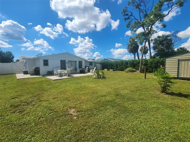 a view of a yard with plants and a fountain