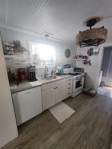 a kitchen with a sink a stove and cabinets