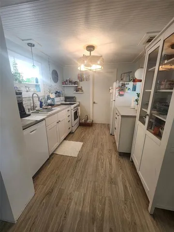 a kitchen with sink a refrigerator and cabinets