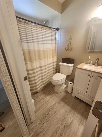 a bathroom with a sink a toilet a mirror and shower
