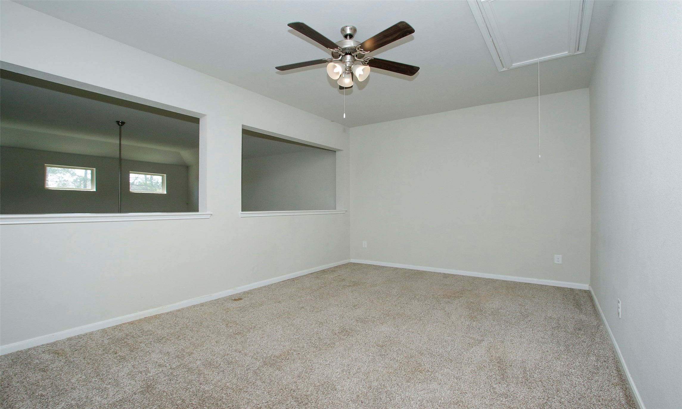 14120 Sand Ridge Court Conroe, TX 77384 - Photo 32 of 43 an empty room with a chandelier fan and windows
