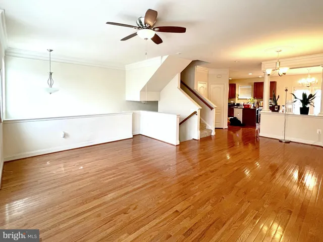 a view of a living room and kitchen with wooden floor