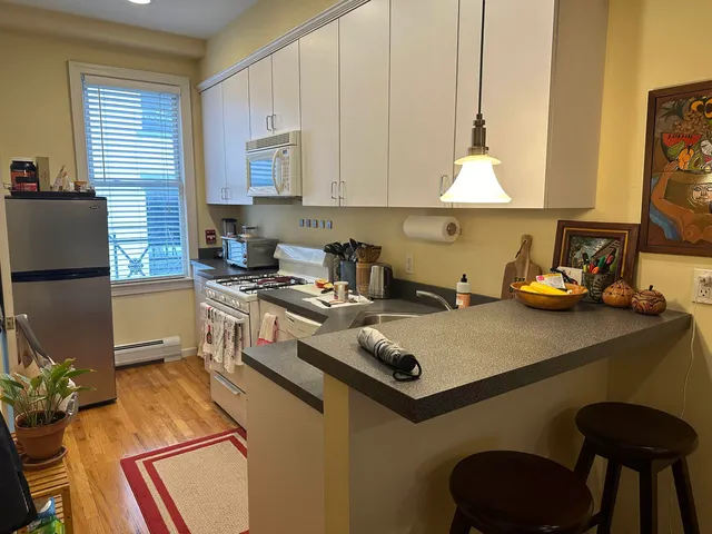 a kitchen with a table chairs refrigerator and cabinets