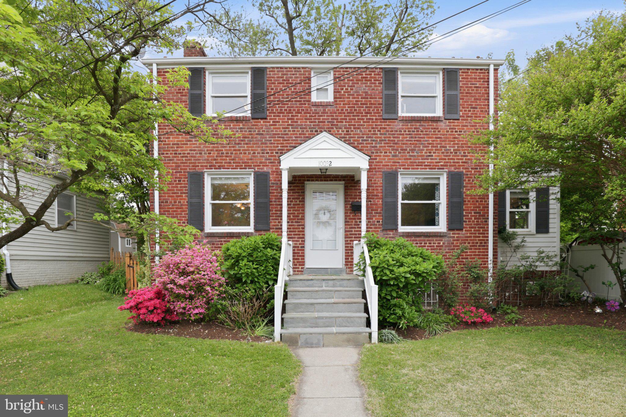 Charming brick home with vibrant gardens.