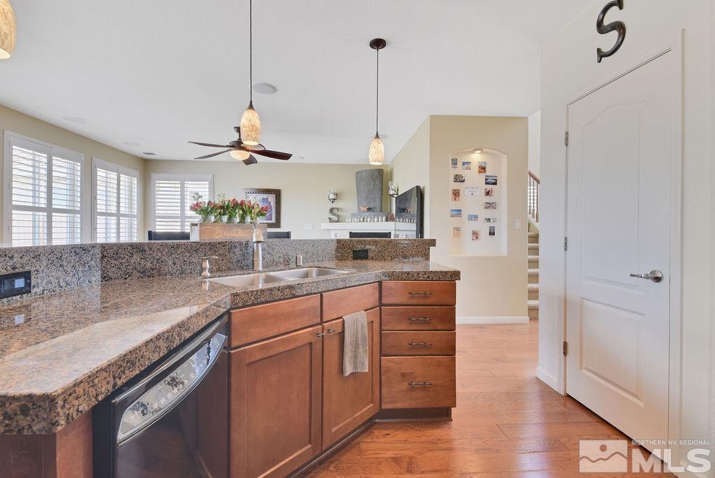 10778 Misty Meadows Drive Reno, NV 89521 - Photo 11 of 40 a kitchen with stainless steel appliances granite countertop a sink a stove a refrigerator and island with wooden floor