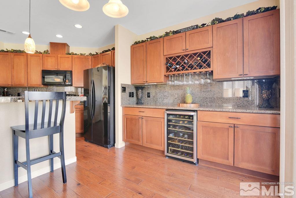 10778 Misty Meadows Drive Reno, NV 89521 - Photo 13 of 40 a kitchen with kitchen island granite countertop a stove a sink and a refrigerator