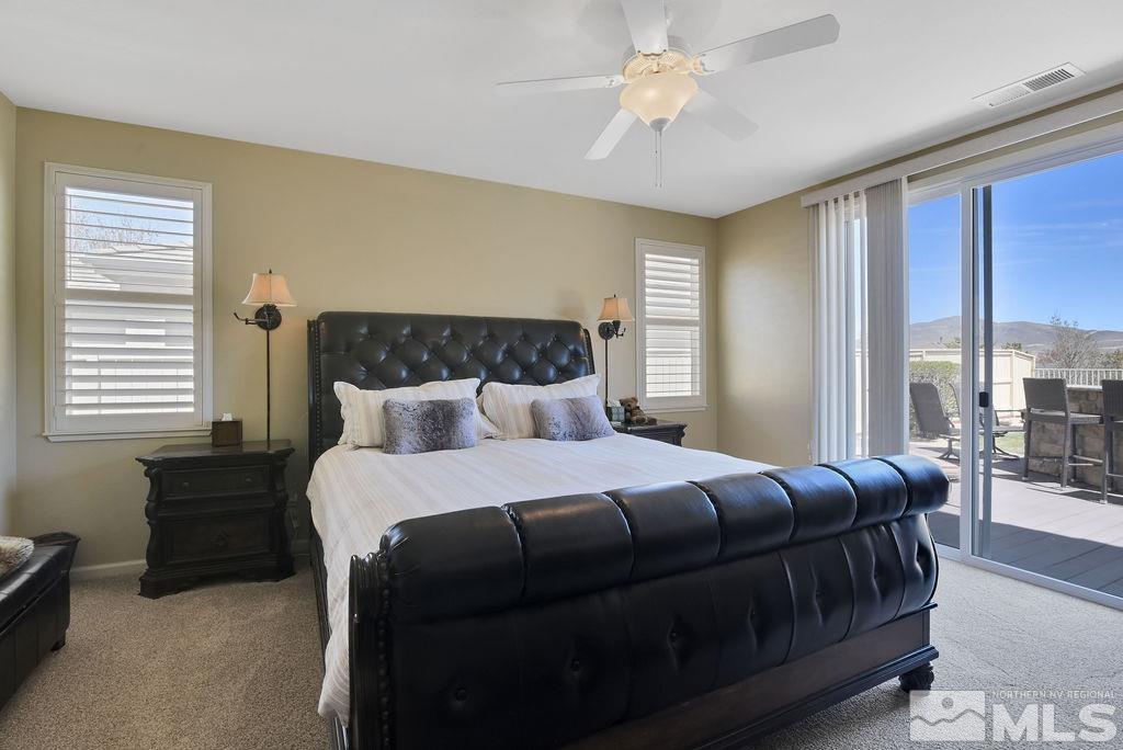 10778 Misty Meadows Drive Reno, NV 89521 - Photo 16 of 40 a bedroom with a large bed and a chandelier