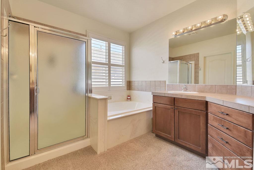 10778 Misty Meadows Drive Reno, NV 89521 - Photo 17 of 40 a bathroom with a tub sink shower and mirror