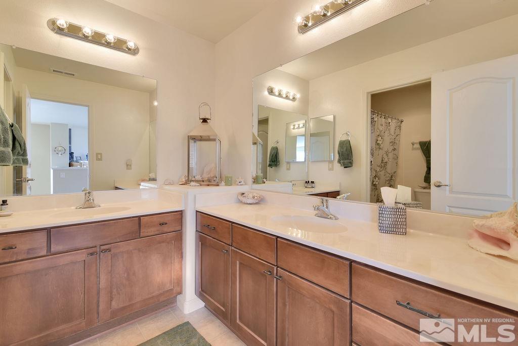 10778 Misty Meadows Drive Reno, NV 89521 - Photo 27 of 40 a bathroom with double sink and a mirror