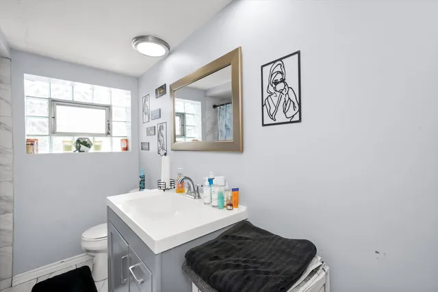 a bathroom with a sink a toilet and a window