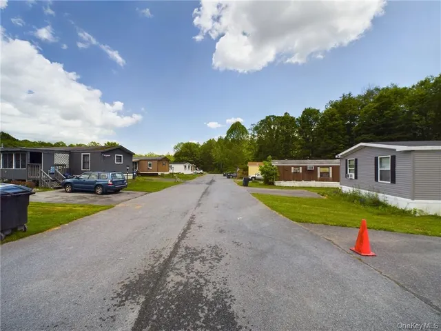 a front view of a house with swimming pool and trees