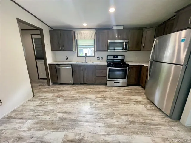a kitchen with granite countertop a refrigerator and a sink