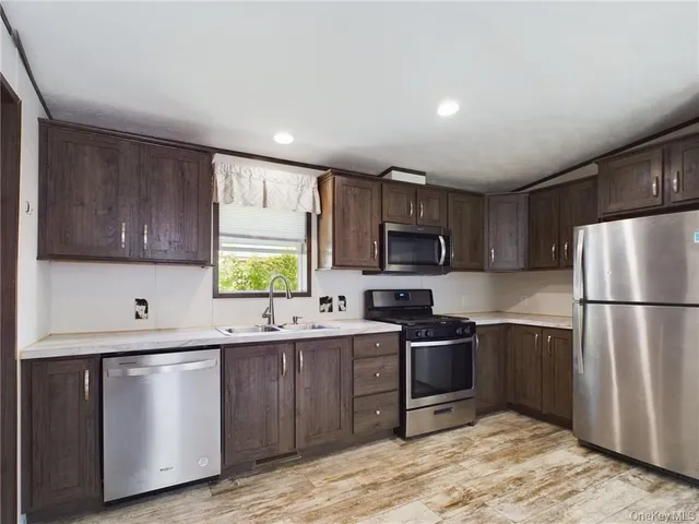 a kitchen with stainless steel appliances granite countertop a refrigerator sink and cabinets