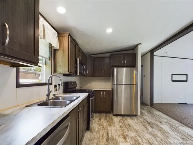 a kitchen with a sink a refrigerator a stove a microwave and cabinets