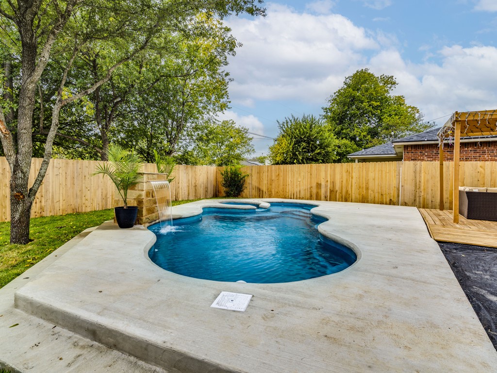 1415 Roxanne's Run Pflugerville, TX 78660 - Photo 26 of 30 A private backyard oasis offers a freeform pool with a stone waterfall feature, perfect for relaxation.