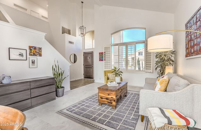 a living room with patio furniture and a potted plant