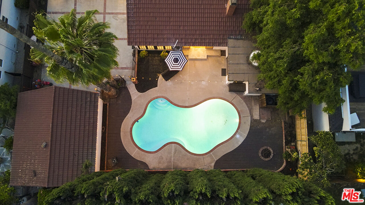 an aerial view of a house with swimming pool and backyard