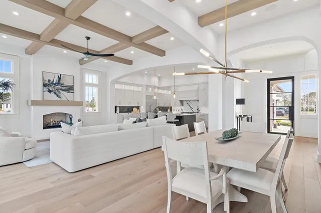 a living room with furniture a table and kitchen view