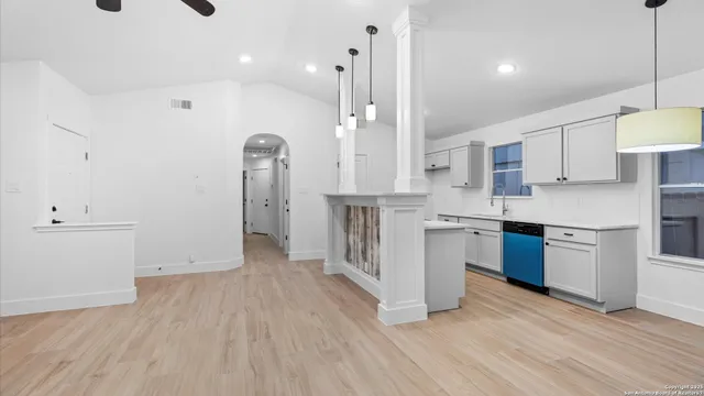a large kitchen with cabinets wooden floor and stainless steel appliances