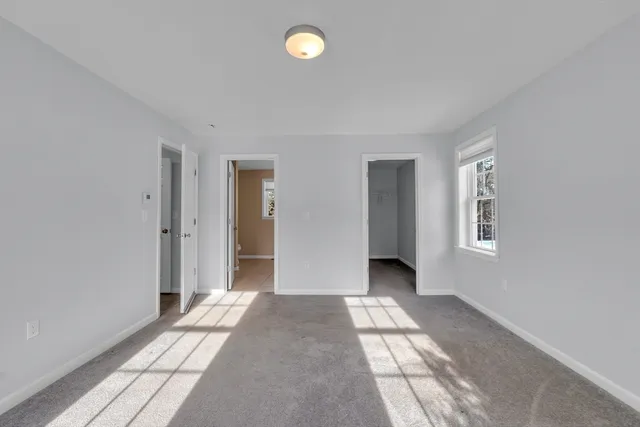 a view of a bedroom with wooden floor and natural light
