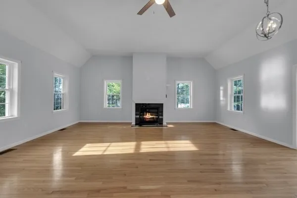 an empty room with windows and fireplace