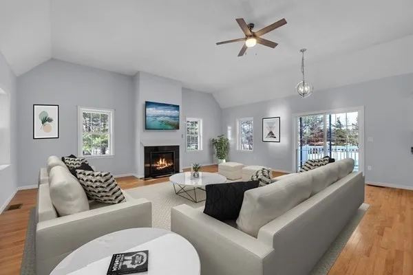 a living room with furniture a fireplace and a large window