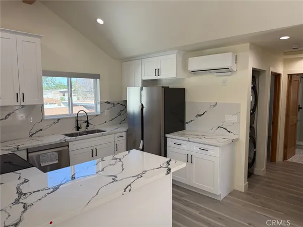 a kitchen with granite countertop a stove a sink and a microwave