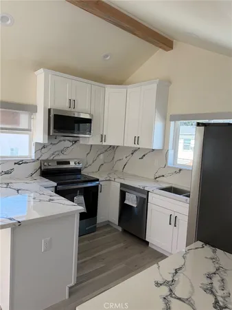 a kitchen with stainless steel appliances a stove a sink a microwave a refrigerator and cabinets