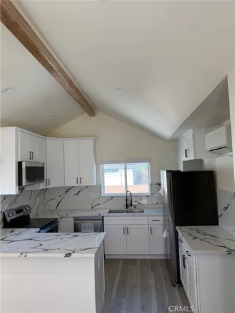 a view of an empty room with wooden floor and closet
