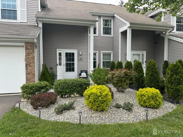 a view of a house with a yard and potted plants