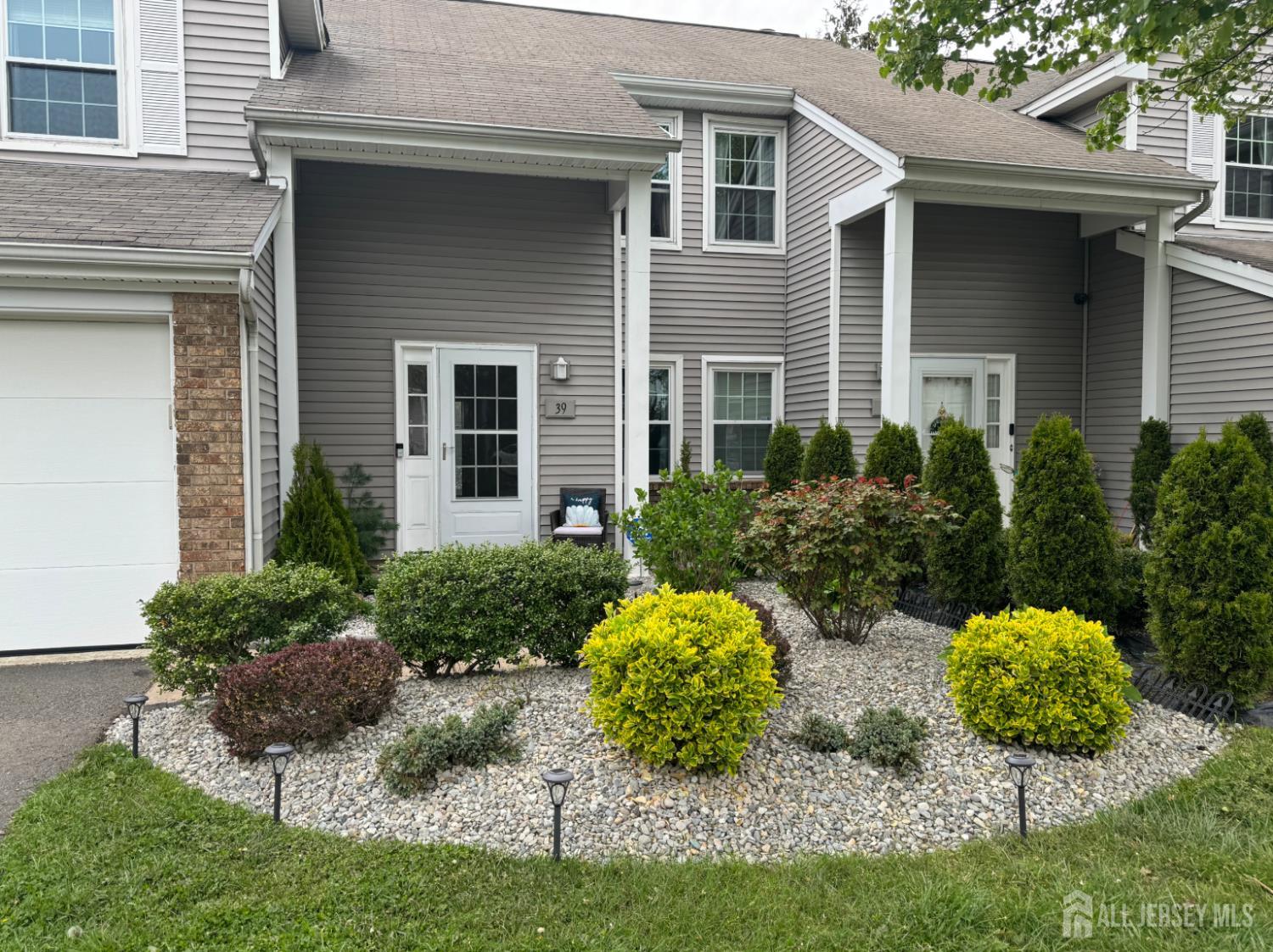 a view of a house with a yard and potted plants