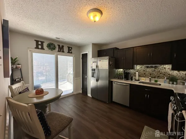 a kitchen with granite countertop a sink appliances and cabinets