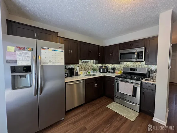 a kitchen with stainless steel appliances granite countertop a refrigerator stove and sink