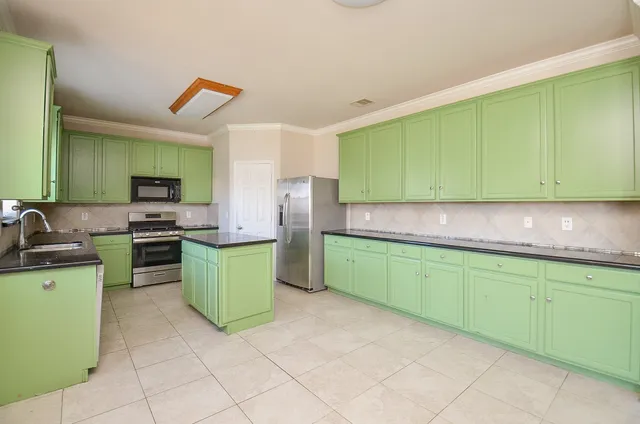 a kitchen with a sink a stove top oven and cabinets