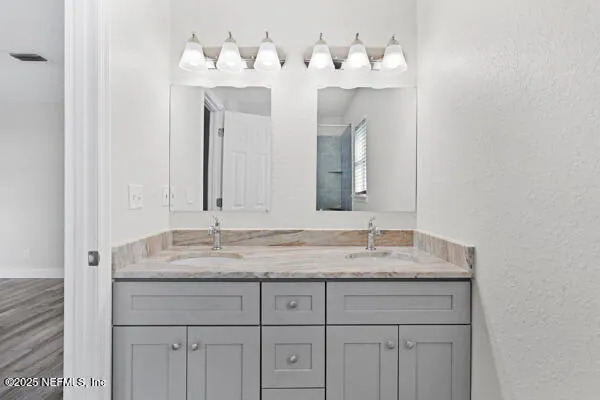 a bathroom with a sink vanity and a mirror