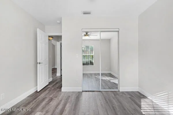 an empty room with wooden floor and windows