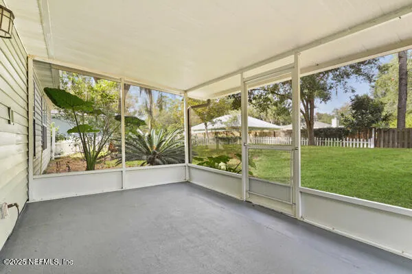 a view of an empty room with floor to ceiling windows and yard